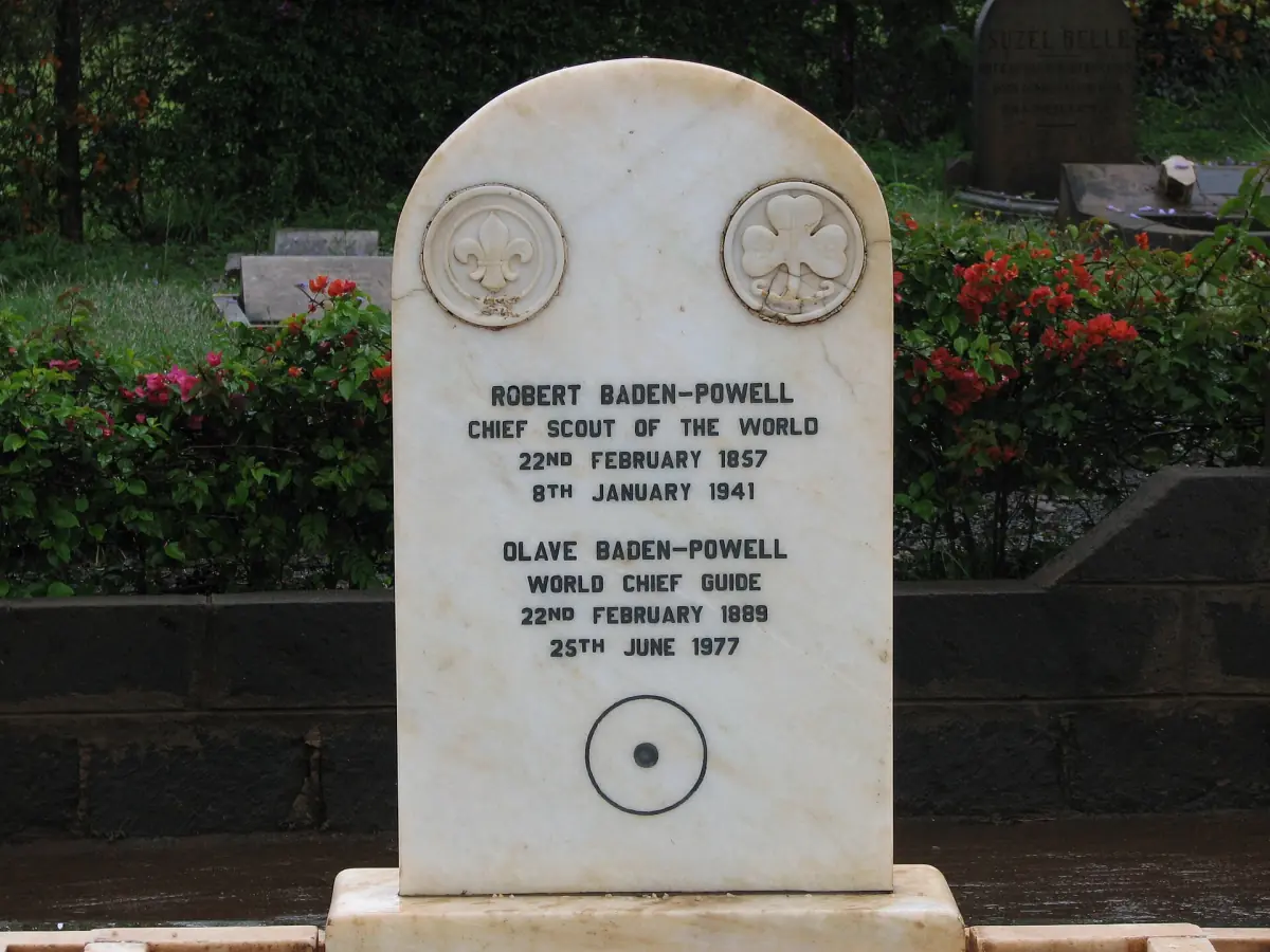 White marble headstone of Robert and Olave Baden-Powell with roses behind