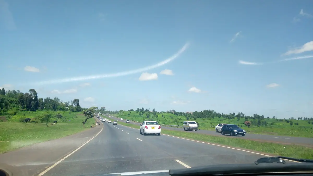 Auto's op de snelweg van Nairobi naar Nyeri onder een heldere, deels onbewolkte hemel