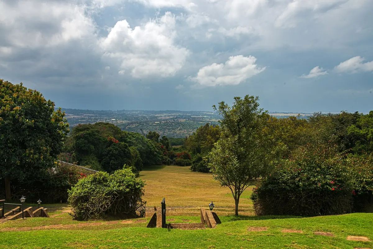 Lawn and trees in a hotel garden with a wide plain beyond