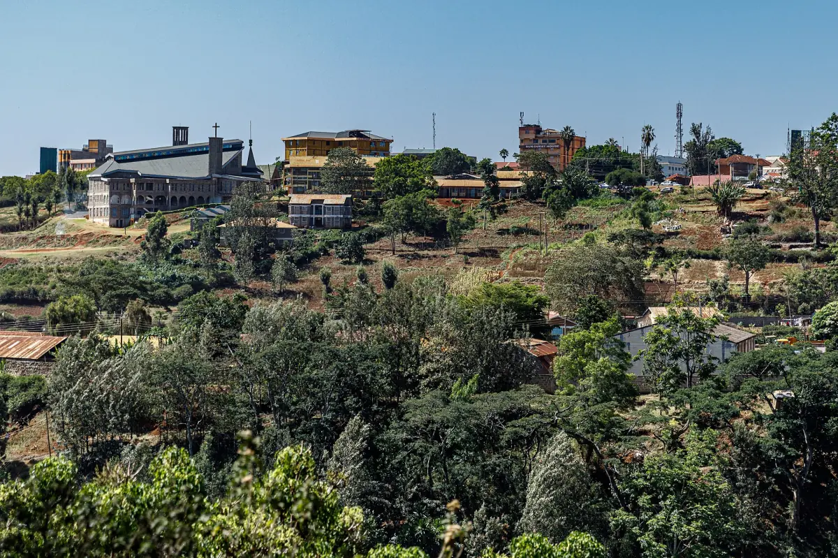 Rooftops and buildings of Nyeri town spread over a green hillside